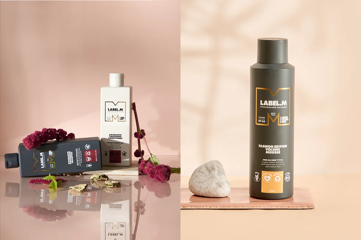 Kollage med två produktbilder från LABEL.M Personalised Haircare. Till vänster visas Amaranth Thickening Shampoo och Amaranth Thickening Conditioner för fine to medium hair, stylade med mörkröda blommor och stenar på en reflekterande yta. Till höger visas Fashion Edition Volume Mousse för all hair types i en mörk flaska placerad bredvid en natursten. Synlig text inkluderar “LABEL.M Personalised Haircare”, “Amaranth Thickening Shampoo”, “Amaranth Thickening Conditioner”, “Fashion Edition Volume Mousse”, “For Fine to Medium Hair”, “For All Hair Types” och 200 ml.