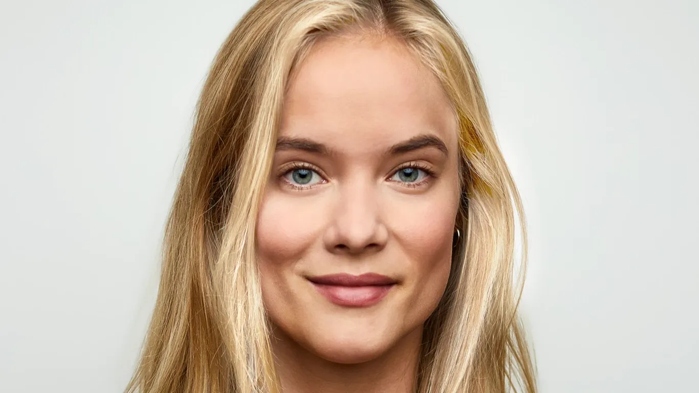 Smilende kvinne med langt blondt hår.