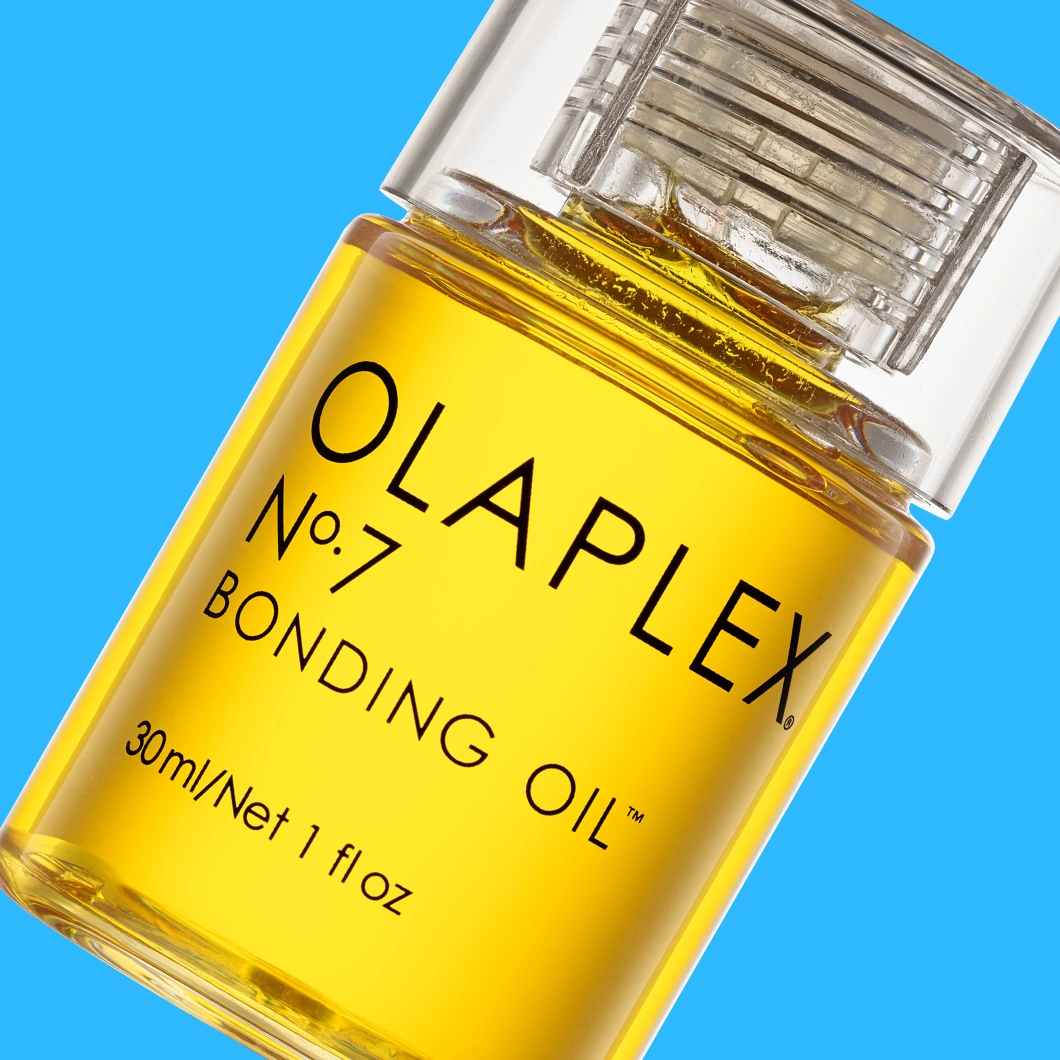 Olaplex No.7 Bonding Oil i genomskinlig flaska med gul olja mot blå bakgrund. På flaskan syns texterna ”OLAPLEX No.7”, ”BONDING OIL” och ”30ml/Net 1 fl oz”.
