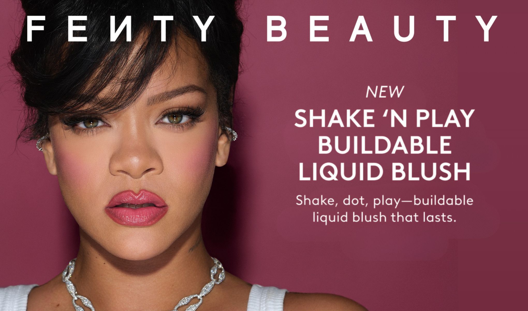 Närbild av person med makeup med rosa rouge och glansiga läppar mot rosa bakgrund, med texten “FENTY BEAUTY”, “NEW SHAKE ‘N PLAY BUILDABLE LIQUID BLUSH” och “Shake, dot, play—buildable liquid blush that lasts.”