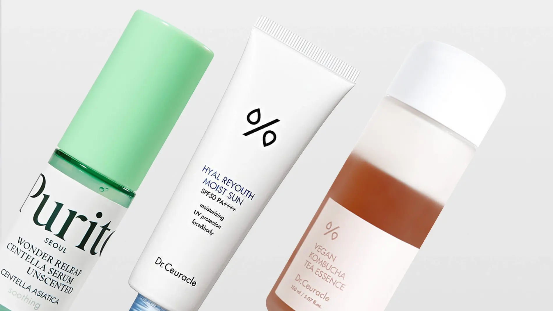 Tre hudpleieprodukter fra Purito Seoul og Dr. Ceuracle vises mot en lys bakgrunn. Produktene har tekstene “Purito Seoul Wonder Releaf Centella Serum Unscented”, “Centella Asiatica”, “soothing”, “Hyal Reyouth Moist Sun SPF50 PA++++”, “moisturizing”, “UV protection”, “face&body” samt “Vegan Kombucha Tea Essence”.