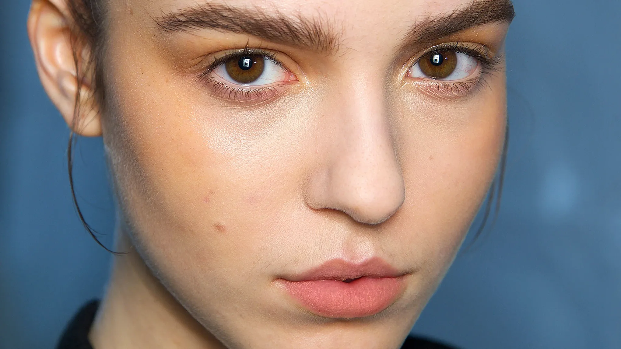 Närbild på ett ansikte med naturlig makeup och välformade ögonbryn.