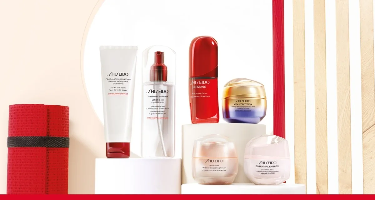 Flera Shiseido hudvårdsprodukter placerade på vita podier mot ljus bakgrund med röda detaljer.