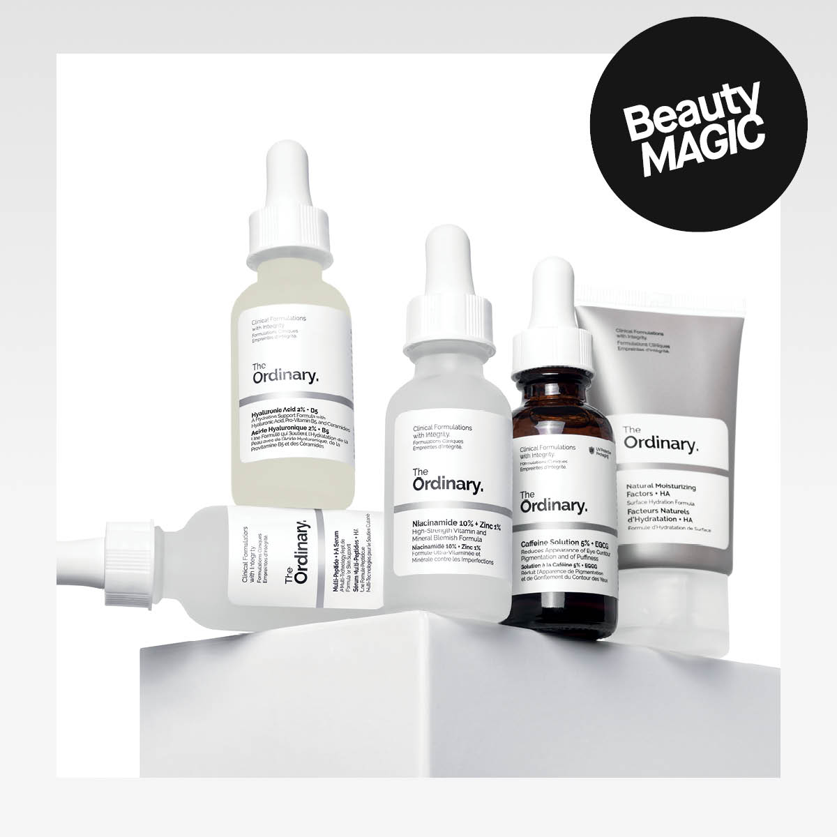 Viisi The Ordinary -tuotetta aseteltuna jalustalle valkoista kliinistä taustaa vasten. Musta tarra tekstillä "BeautyMagic!".