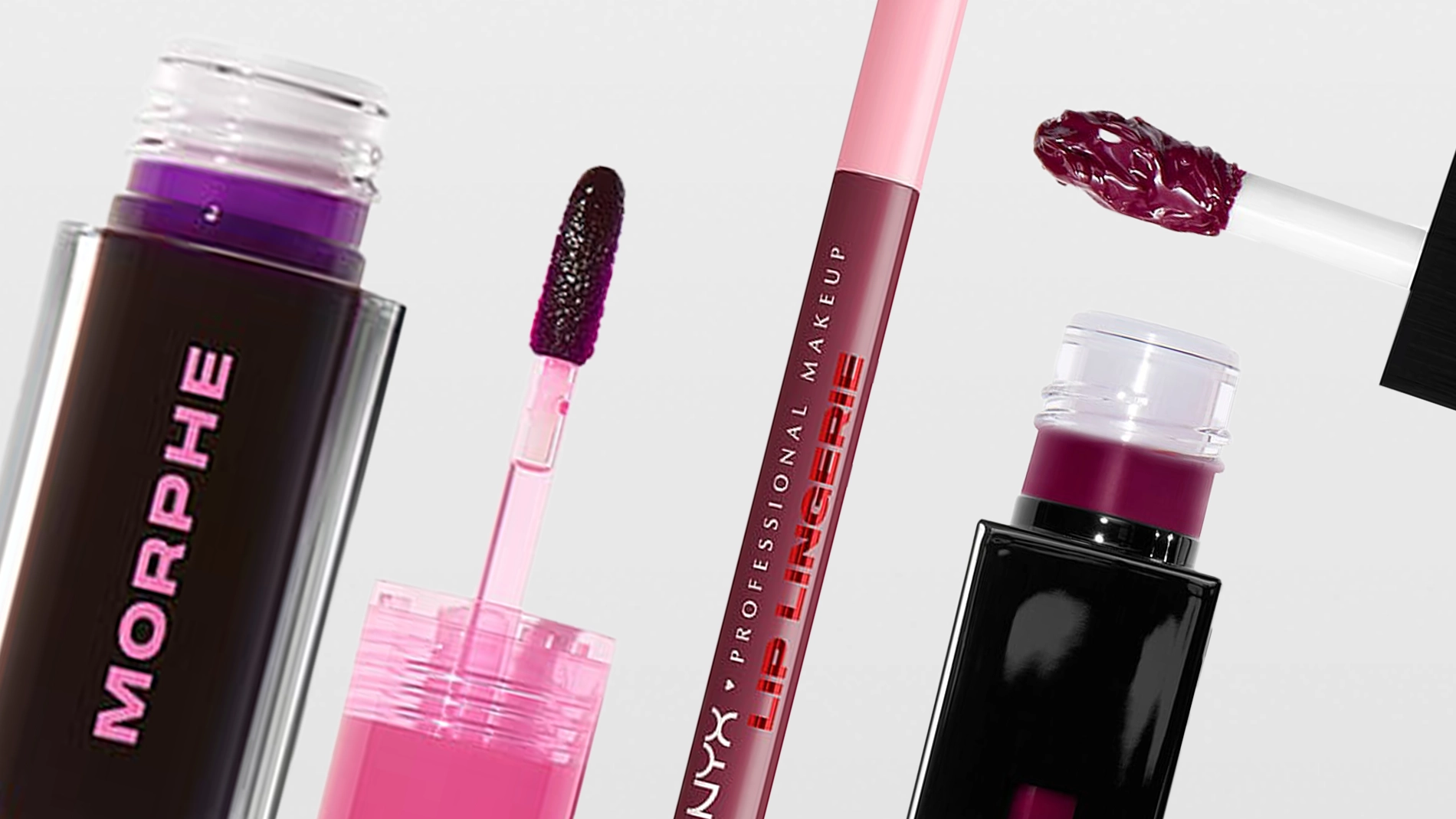 Närbild av flera flytande läpprodukter mot ljus bakgrund. Öppna förpackningar med applikatorer syns, fyllda med pigment i rosa och mörklila nyanser. En applikator med färg är placerad ovanför förpackningen.