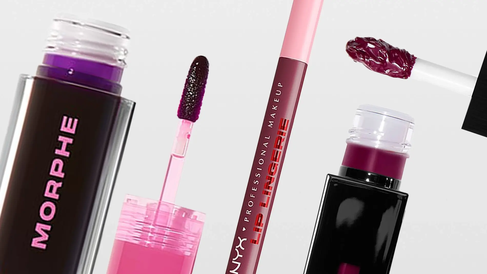 Närbild av flera flytande läpprodukter mot ljus bakgrund. Öppna förpackningar med applikatorer syns, fyllda med pigment i rosa och mörklila nyanser. En applikator med färg är placerad ovanför förpackningen.