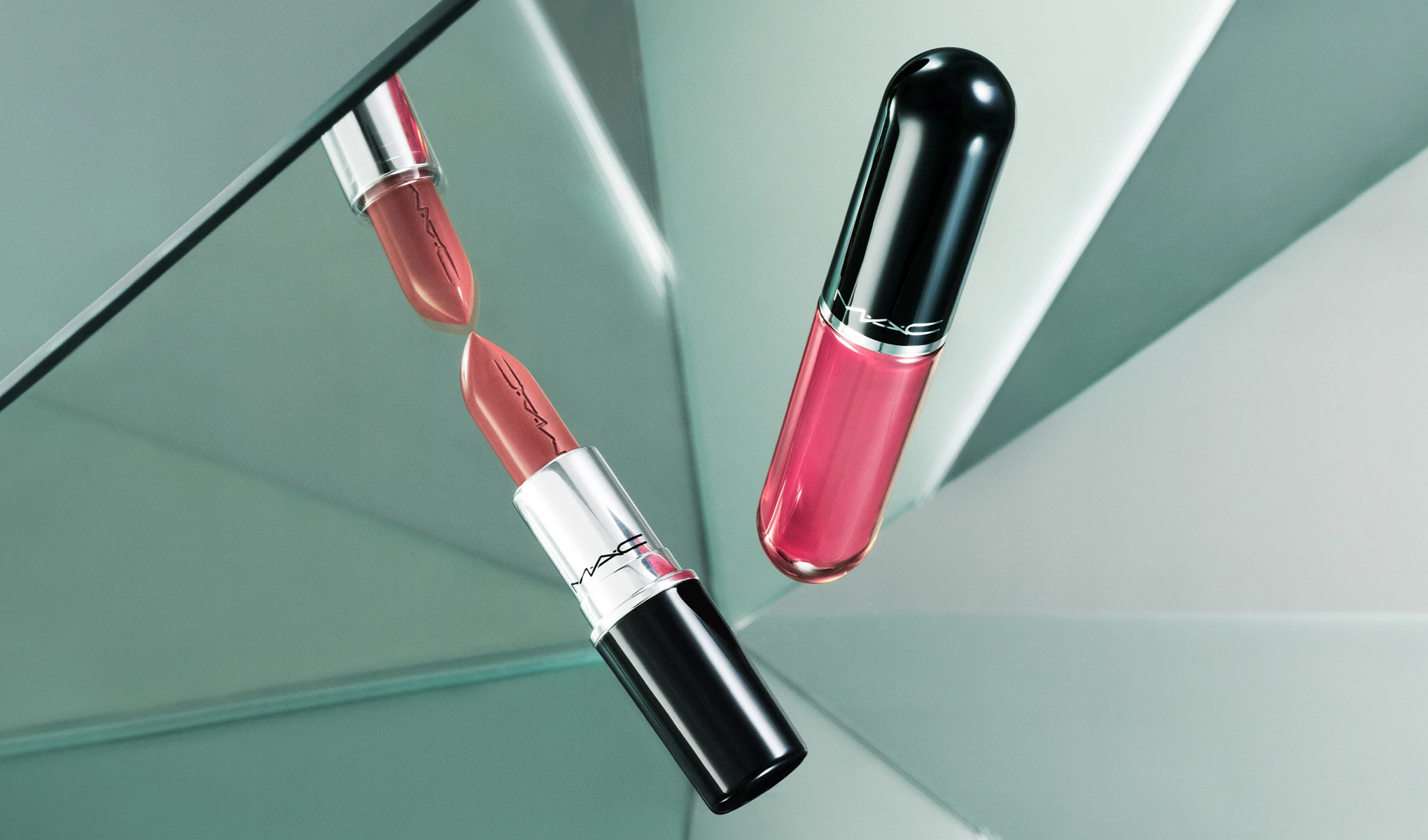En MAC-leppestift i nude-rosa nyanse og en rosa lipgloss svever foran speilflater som reflekterer produktene. MAC-logoen vises på begge produktene, og spissen på leppestiften speiles i det skråstilte speilet.