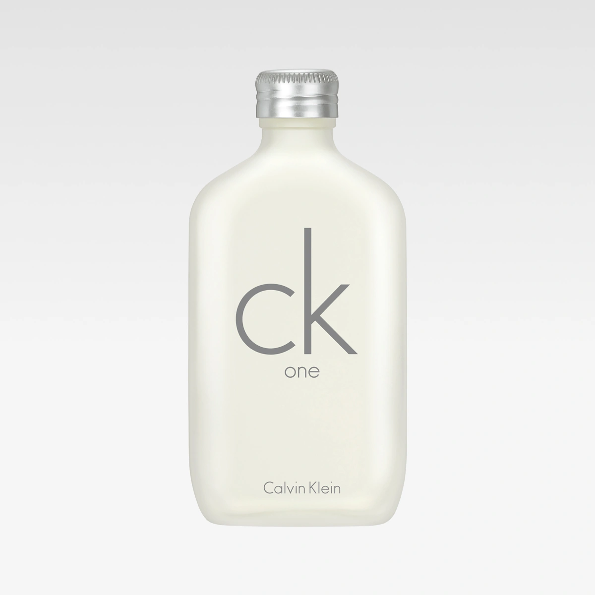 Calvin Klein CK One -hajuvesipullo valkoisella designilla ja hopeanvärisellä korkilla vaaleanharmaata taustaa vasten. Näkyvä teksti sisältää “ck one” ja “Calvin Klein”.