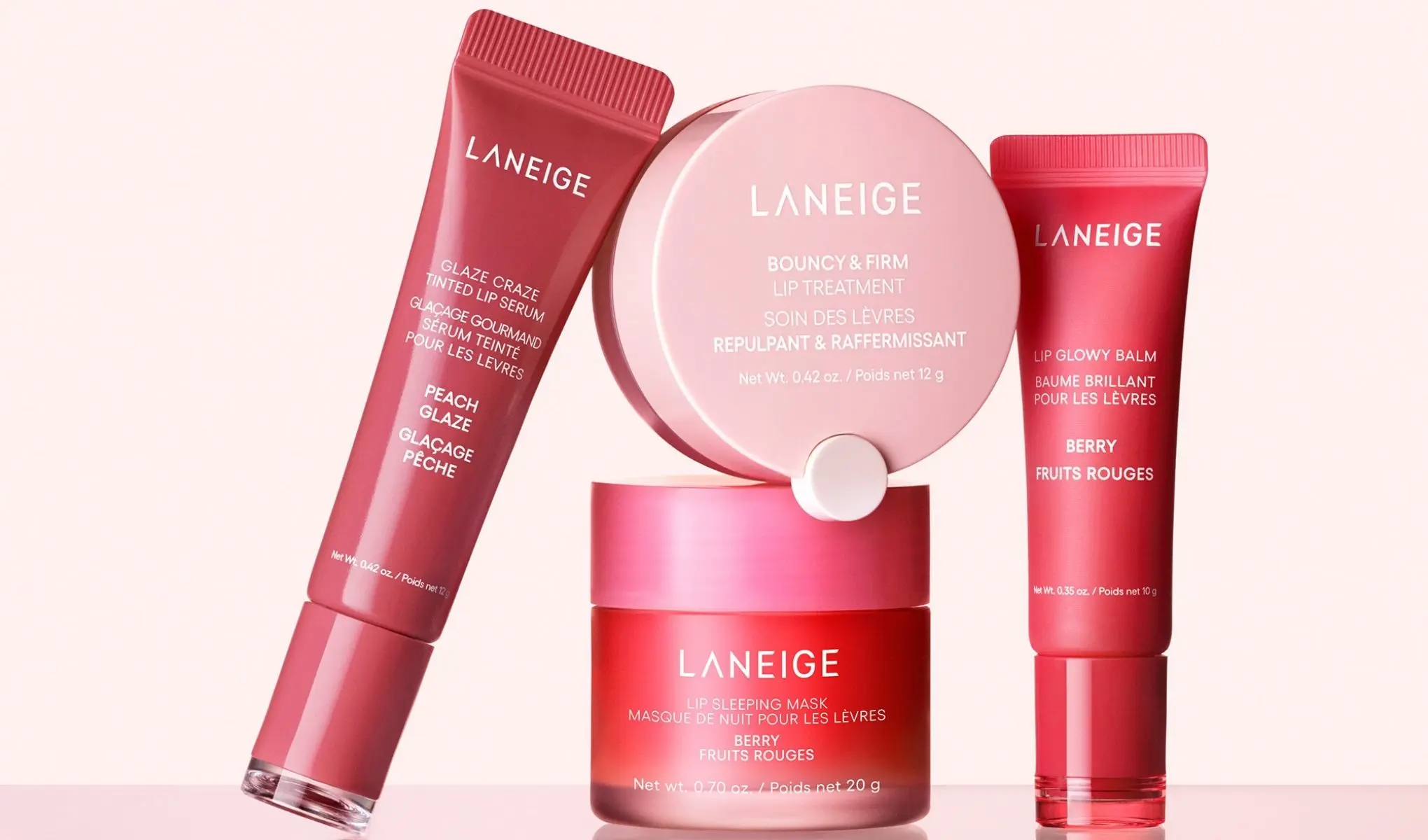 Laneige-tuotteiden kokoelma, joka sisältää huuliseerumin, huulivoiteen, huulihoidon ja huulinaamion. Tuotteet ovat punertavissa sävyissä ja niissä on tekstiä sekä englanniksi että ranskaksi.