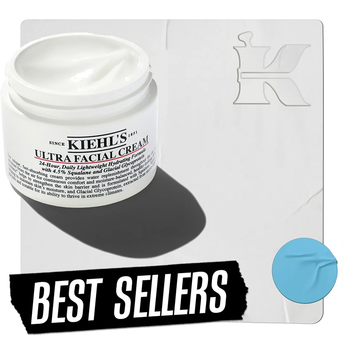 En burk Kiehl's Ultra Facial Cream placerad mot en ljus bakgrund. I nedre vänstra hörnet finns texten "Best Sellers" och i övre högra hörnet syns Kiehl's logotyp. En blå cirkel är placerad i nedre högra hörnet.