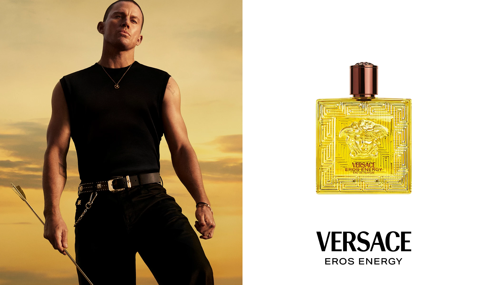 Mustiin pellaviin ja mustiin housuihin pukeutunut mies pitelee kultaista nuolta auringonlaskun taustaa vasten. Oikealla on keltainen hajuvesipullo, jossa lukee ”Versace Eros Energy”.