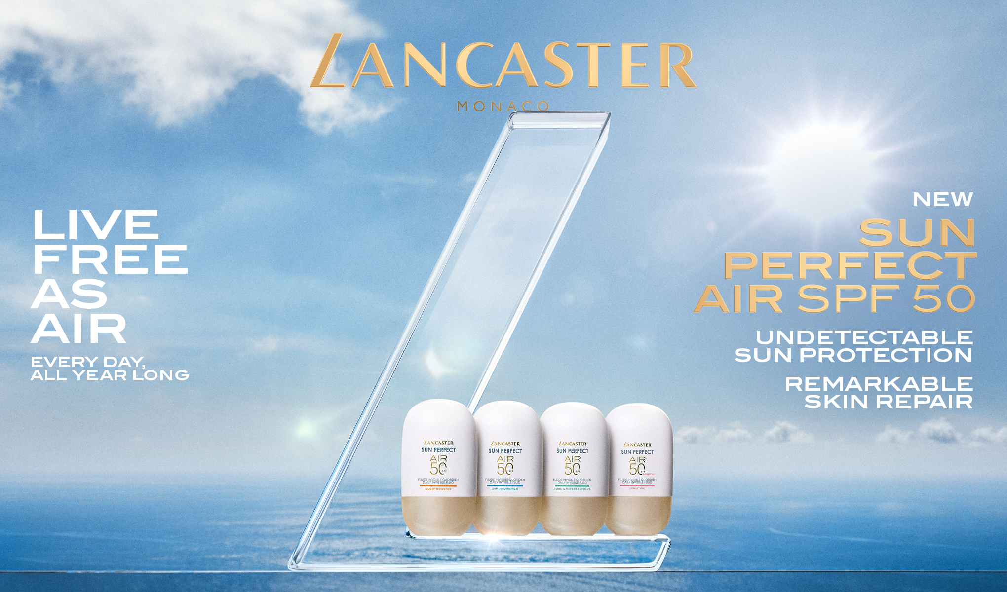 Kampanjebilde fra Lancaster Monaco med fire solbeskyttelsesprodukter “Sun Perfect Air SPF 50” plassert i en transparent display mot hav og himmel. Tekst i bildet: “LANCASTER MONACO”, “LIVE FREE AS AIR”, “EVERY DAY, ALL YEAR LONG”, “NEW SUN PERFECT AIR SPF 50”, “UNDETECTABLE SUN PROTECTION” og “REMARKABLE SKIN REPAIR”.