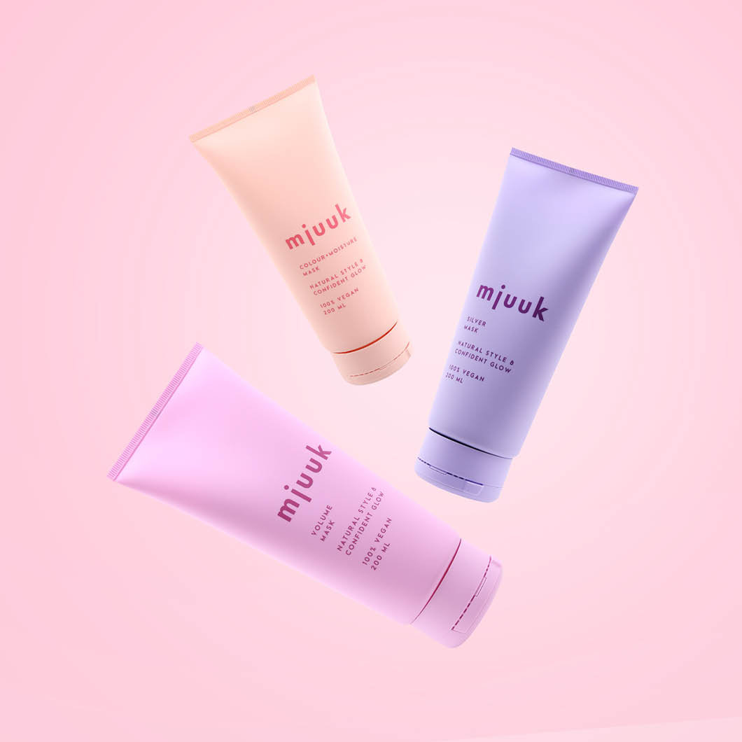 Tre fargerike tuber med merkingen "mjuuk". Tubene er rosa, lys lilla og ferskenfarget, og har tekst som informerer om at de er veganske.