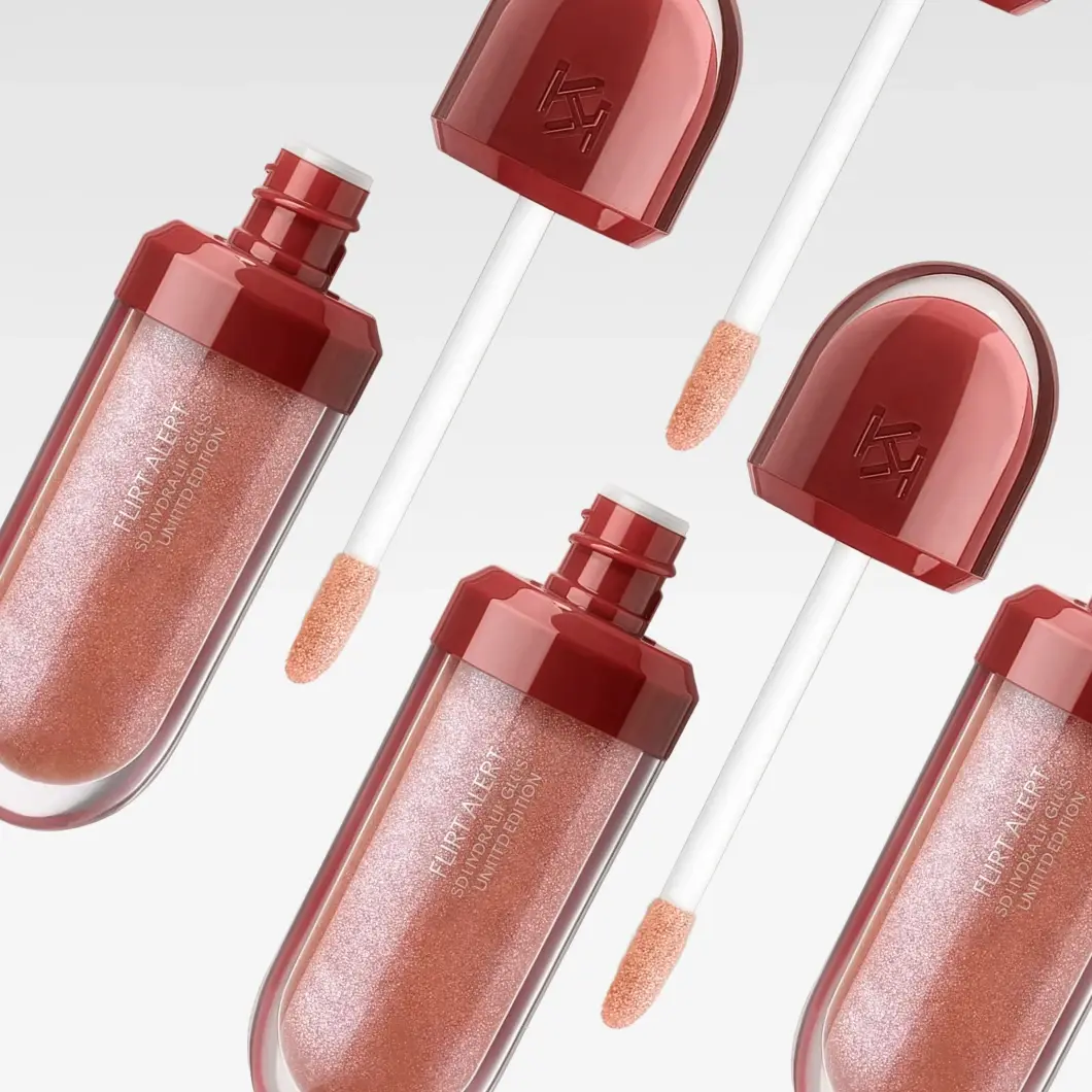 Flere KIKO MILANO lip gloss-produkter vises mot lys grå bakgrunn med åpne applikatorer. Emballasjen har teksten “FLIRT ALERT”, “3D HYDRA LIP GLOSS” og “LIMITED EDITION”, og glossen har en skimrende roségull farge.