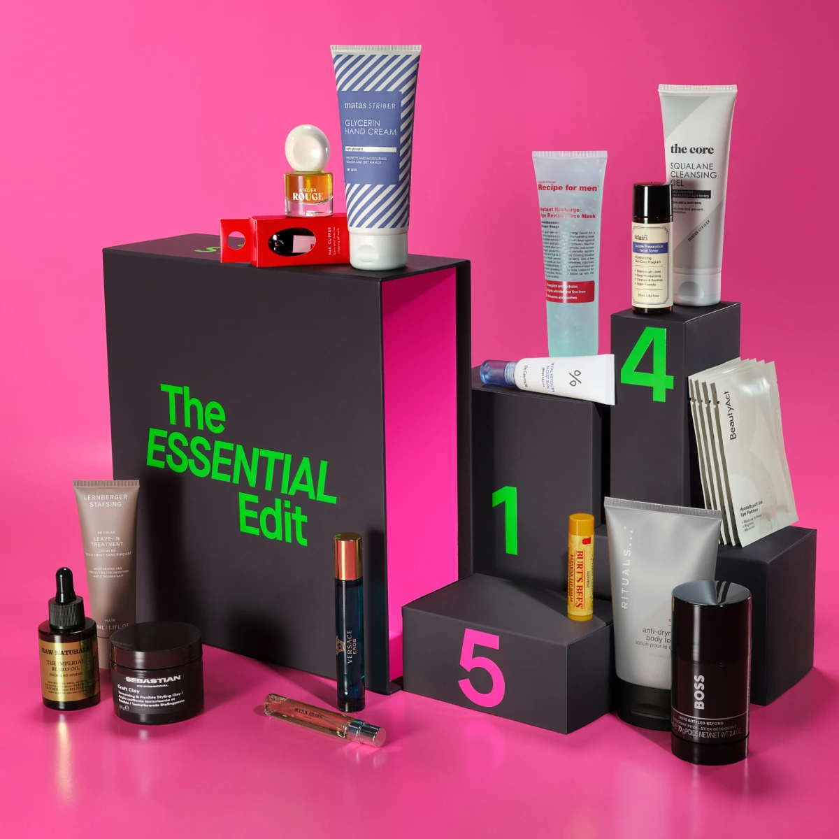 Ett urval av vård- och skönhetsprodukter, som krämer och oljor, arrangerade runt en svart låda märkt 'The ESSENTIAL Edit'.