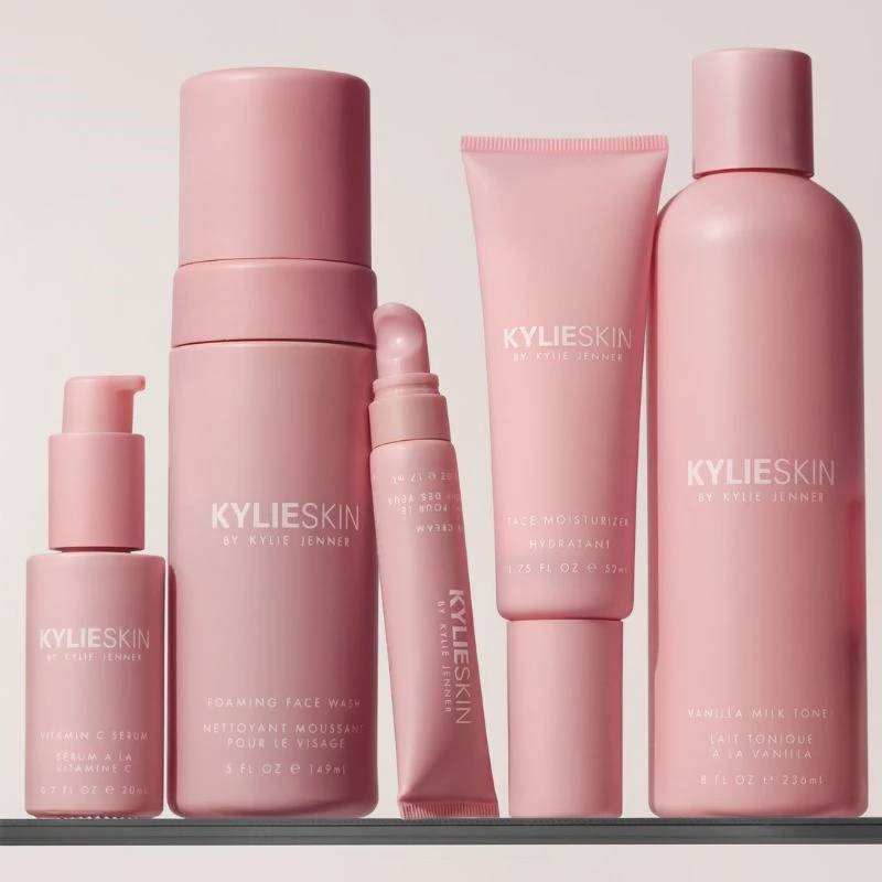 Vaaleanpunaisia ihonhoitotuotteita Kylie Cosmeticsilta beigen taustan edessä.