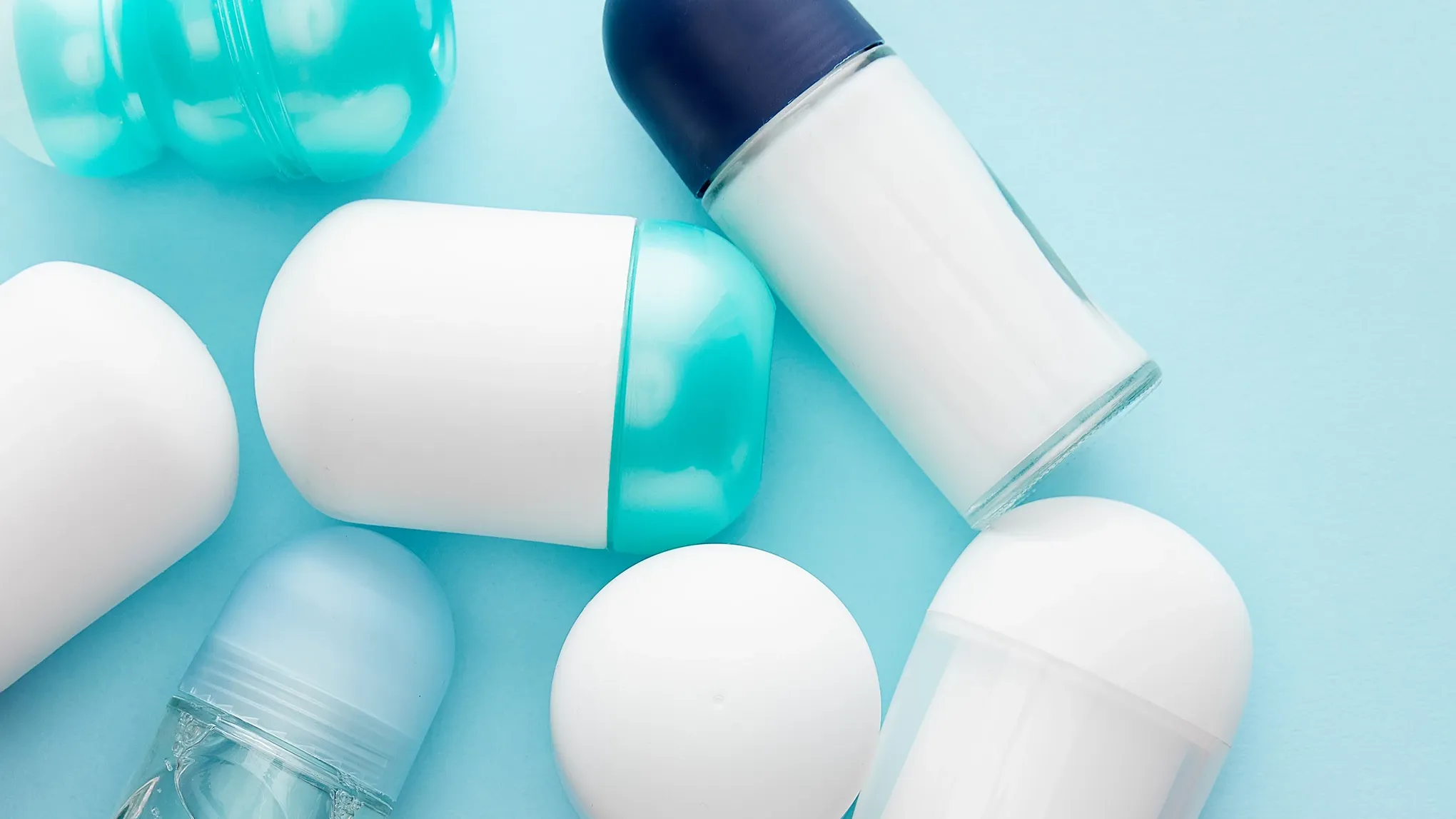 Kokoelma deodorantteja ja antiperspirantteja vaaleansinisellä taustalla.