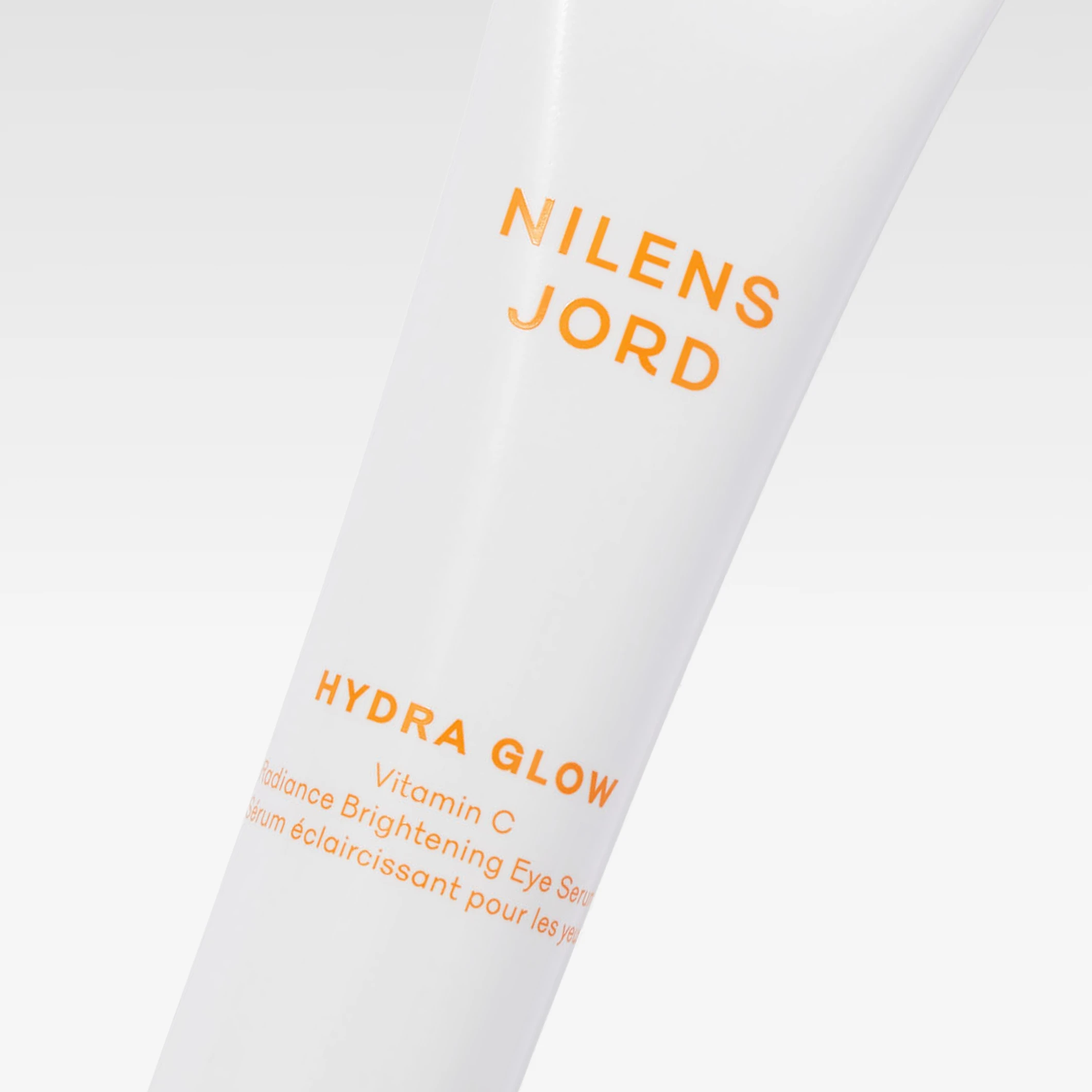Nilens Jord Hydra Glow Vitamin C øyeserum i hvit tube med teksten "NILENS JORD HYDRA GLOW Vitamin C".