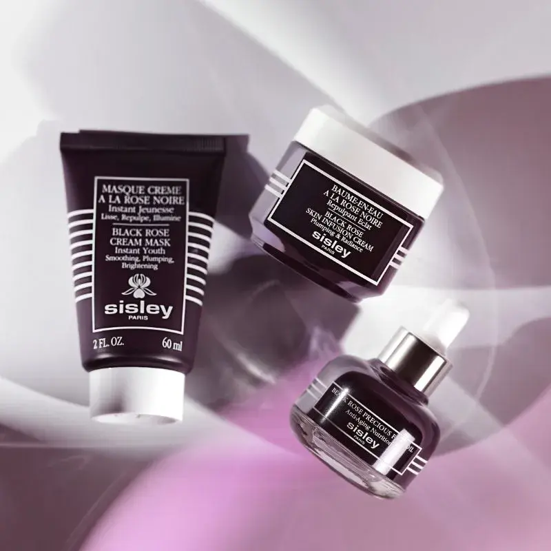 Tre mörka behållare från Sisley Paris: "Black Rose Cream Mask", "Black Rose Skin Infusion Cream", "Black Rose Precious Face Oil".