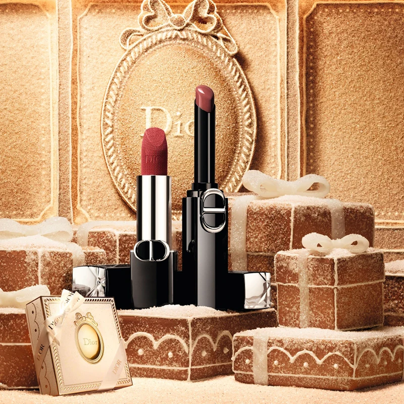 To Dior-leppestifter, en matt rød og en glansfull nude, står blant festlige pepperkakegaveesker dekket med sukker.