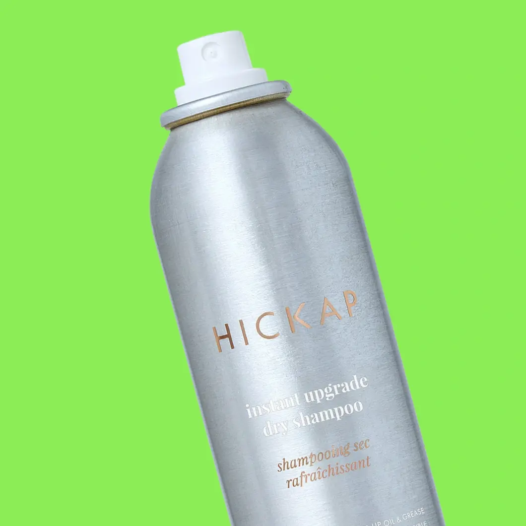 Hopeinen HICKAP Instant Upgrade Dry Shampoo -suihkepullo valkoisella suuttimella kirkkaanvihreällä taustalla.