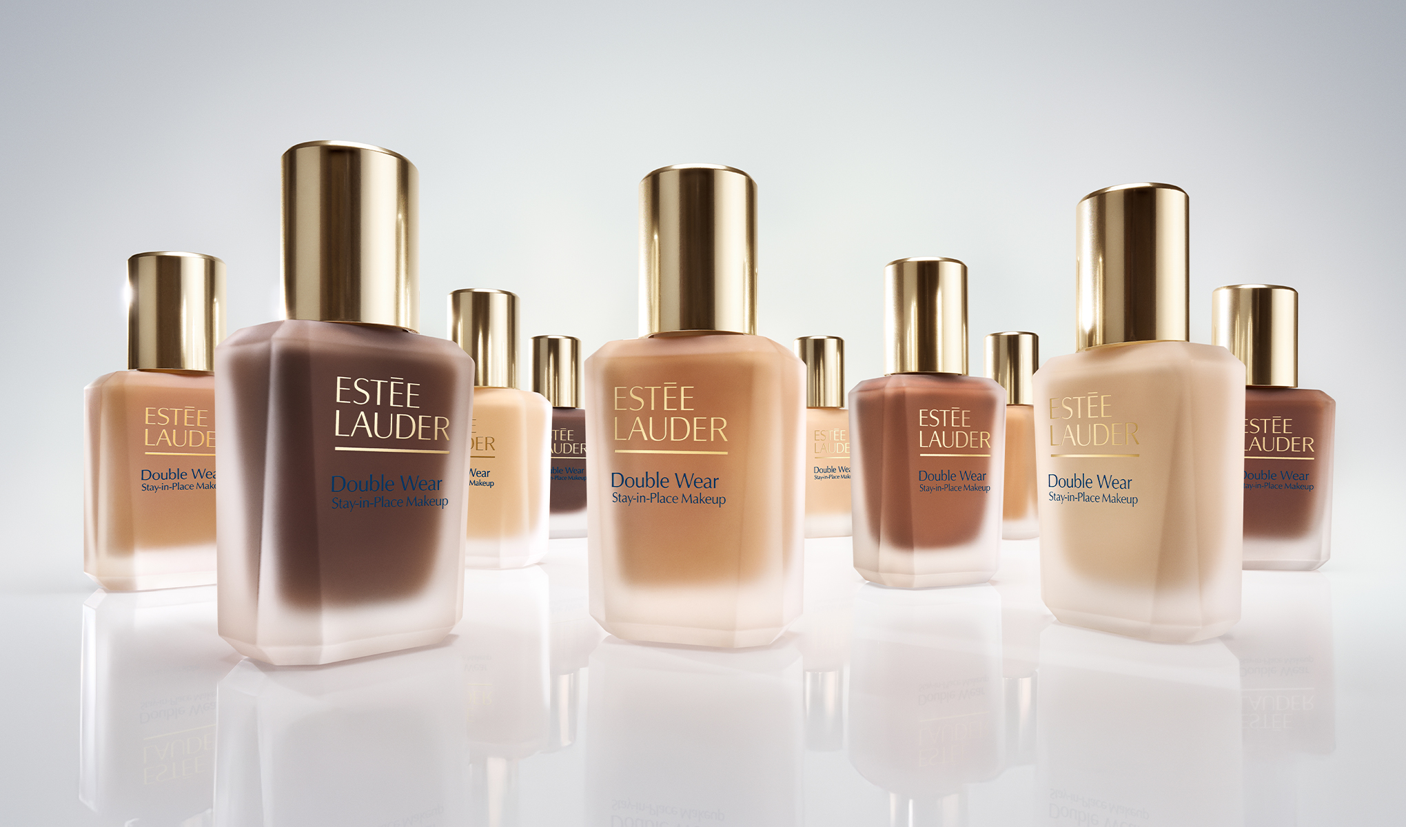 Useita Estée Lauder Double Wear Stay-in-Place -meikkivoidepulloja eri sävyissä vaaleasta tummaan, aseteltuna vaalealle taustalle.