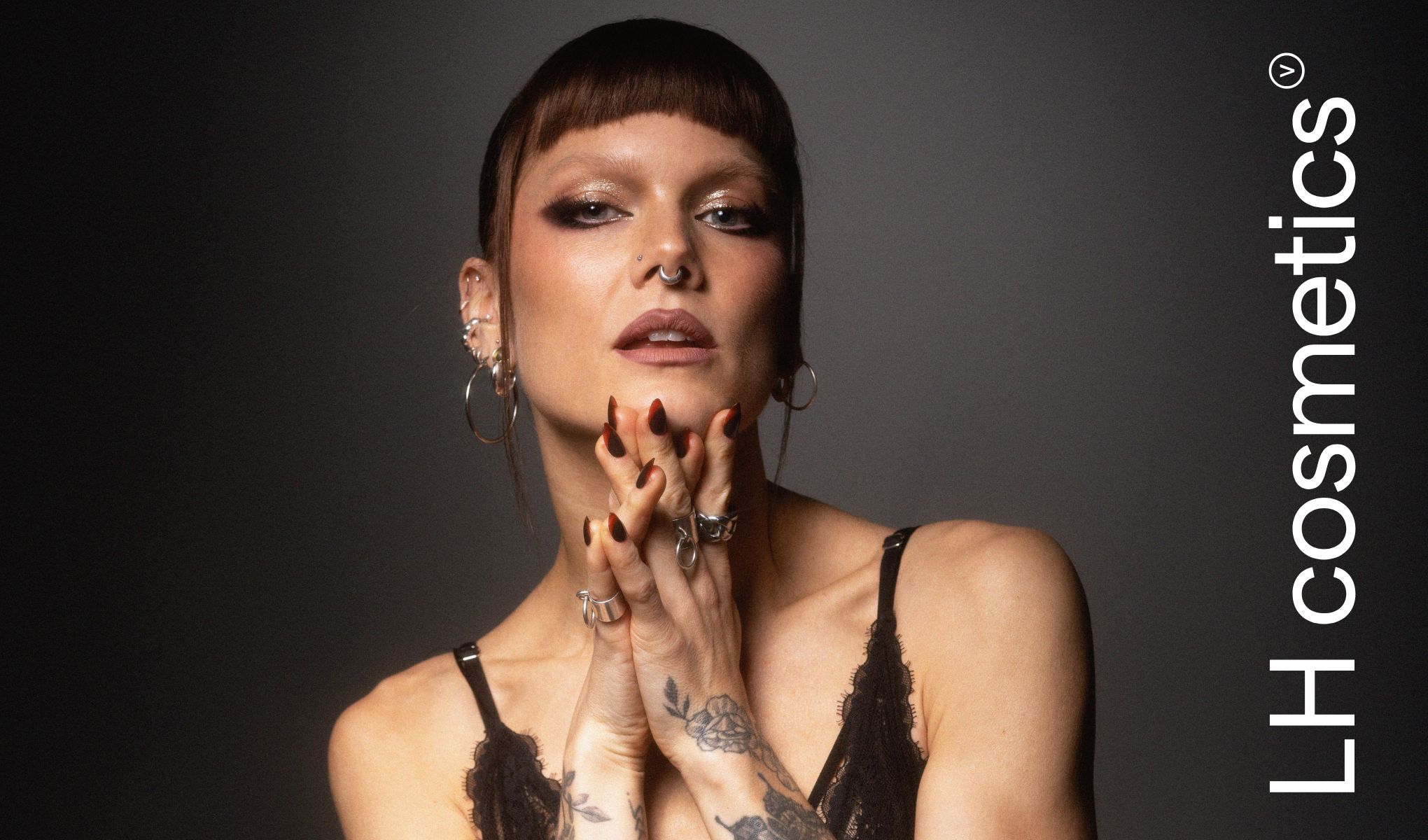 En person med sølvsmykker og flere øredobber.