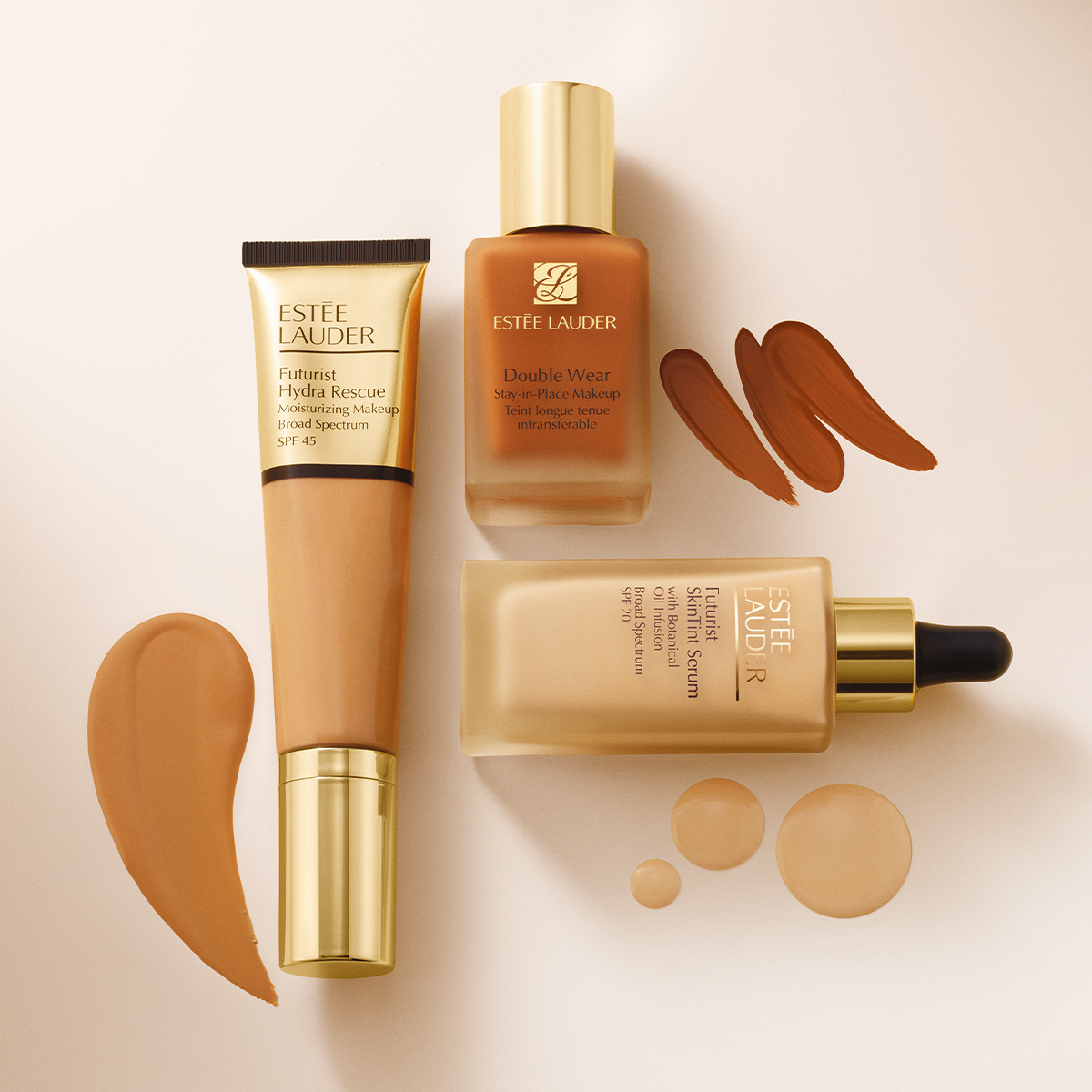 Estee Lauder-sminkeprodukter, inkludert Futurist Hydra Rescue fuktighetsgivende foundation, Double Wear foundation og Futurist SkinTint serum, arrangert på en hvit bakgrunn.