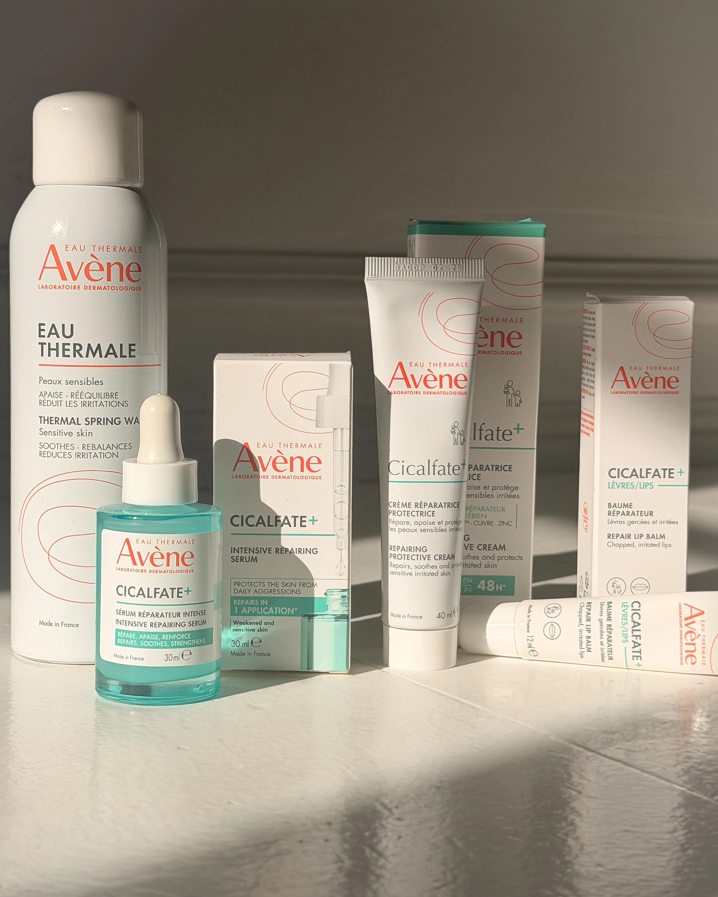En samling af Avène produkter: Eau Thermale spray, Cicalfate+ serum, Cicalfate+ creme og Cicalfate+ læbepomade.