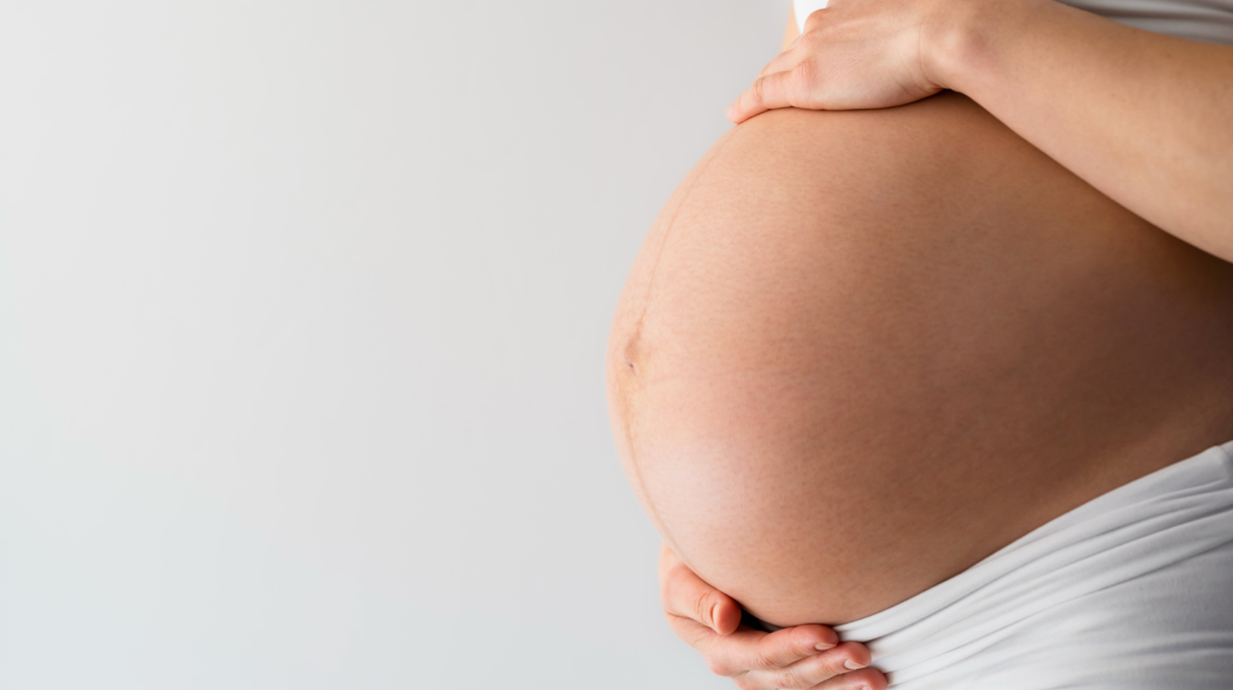 En gravid person holder sin mave.