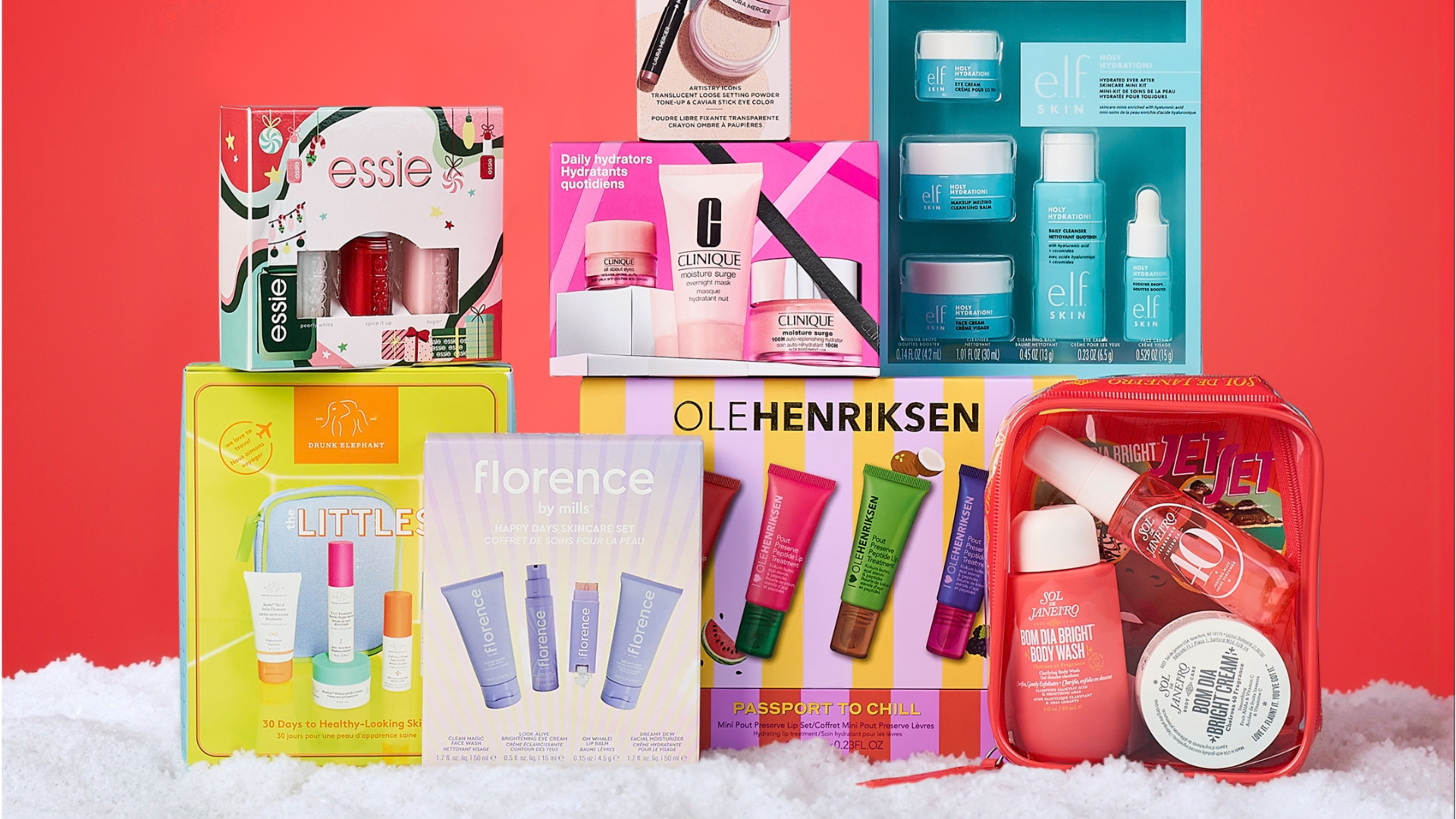 Diverse skønheds- og hudplejegavesæt fra populære mærker, arrangeret på en rød baggrund med sneeffekt.