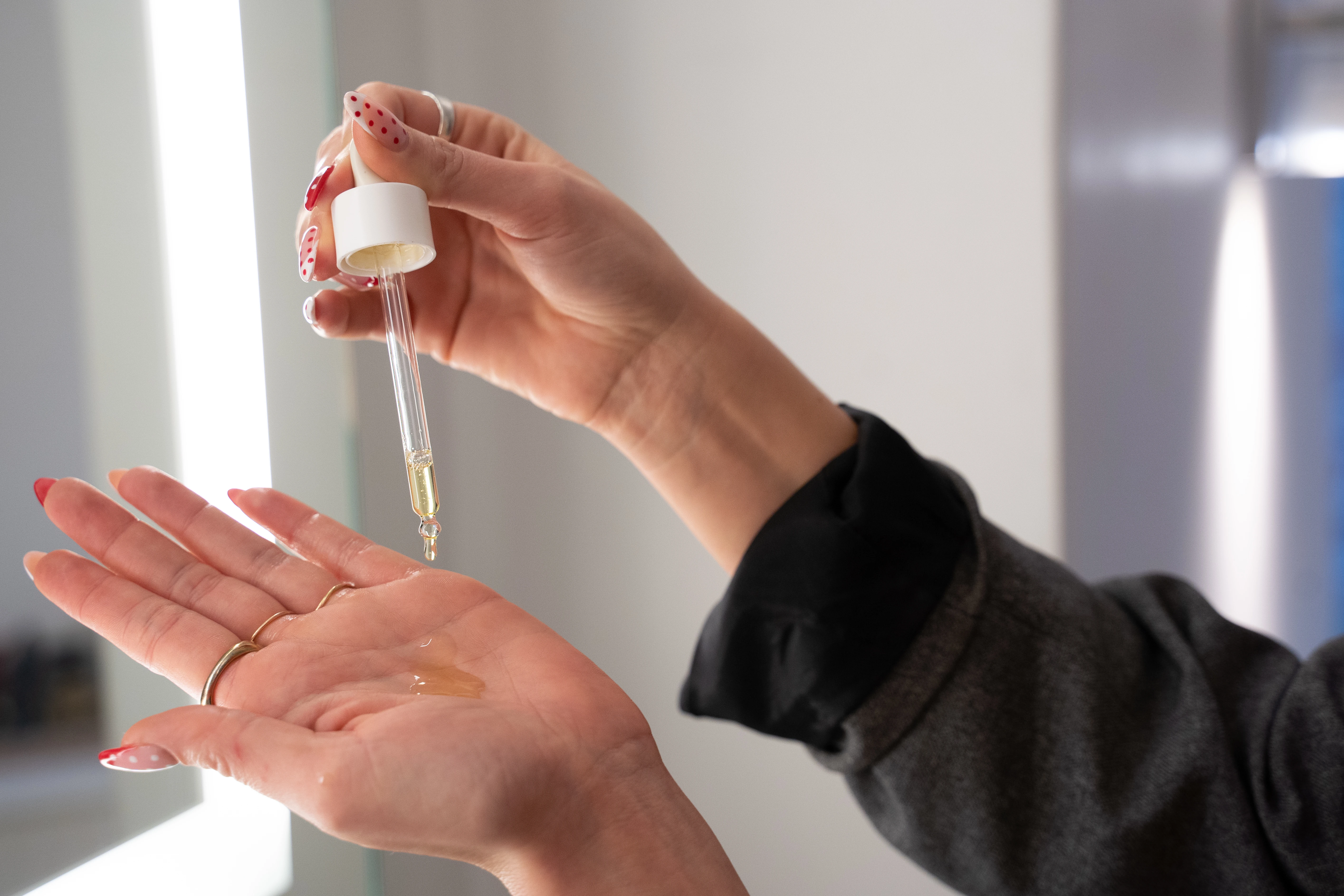 Kvinde, der tager serum ud i sin hånd for at vise konsistensen 