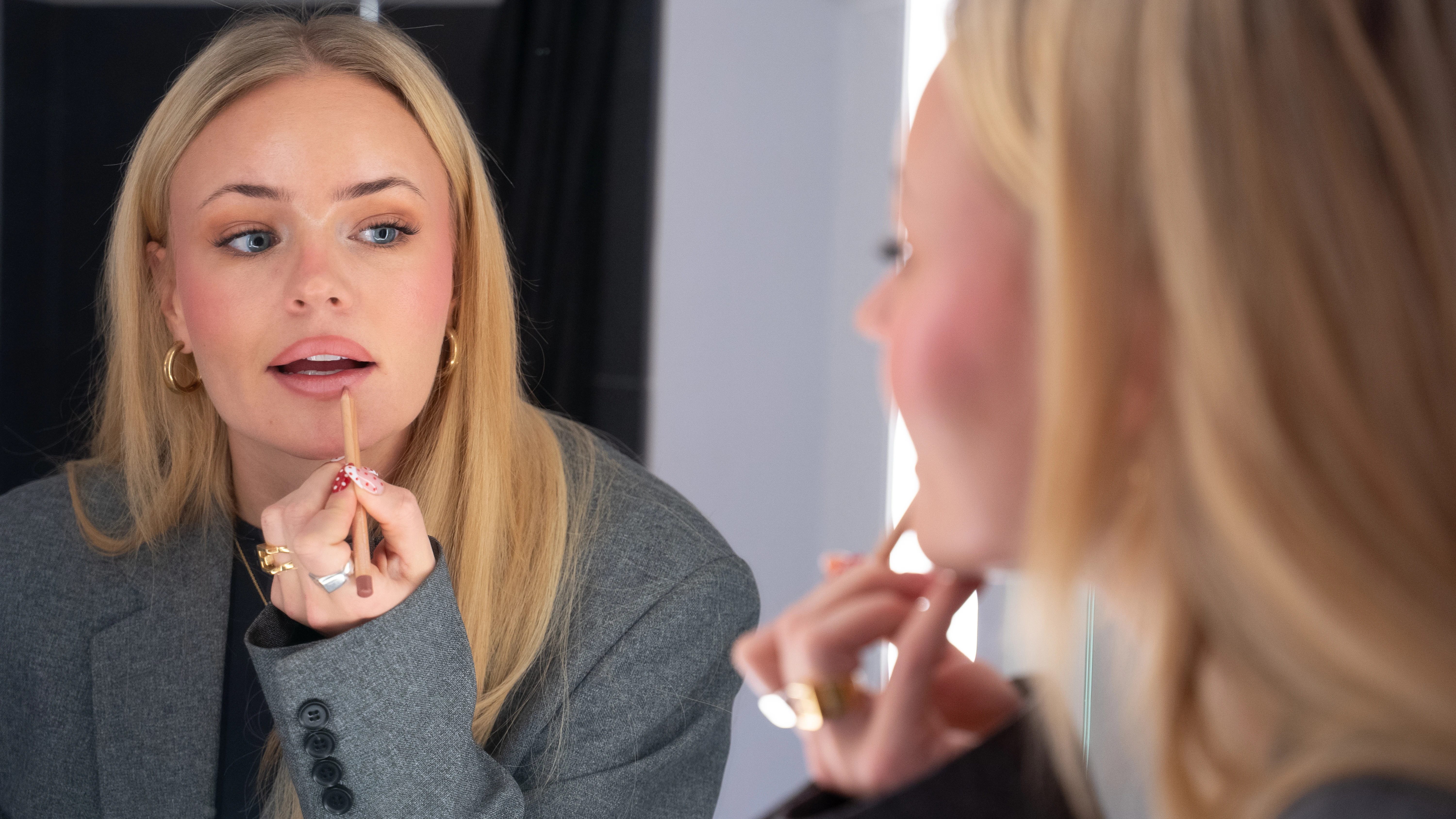 Kvinde der påfører lipliner i spejl