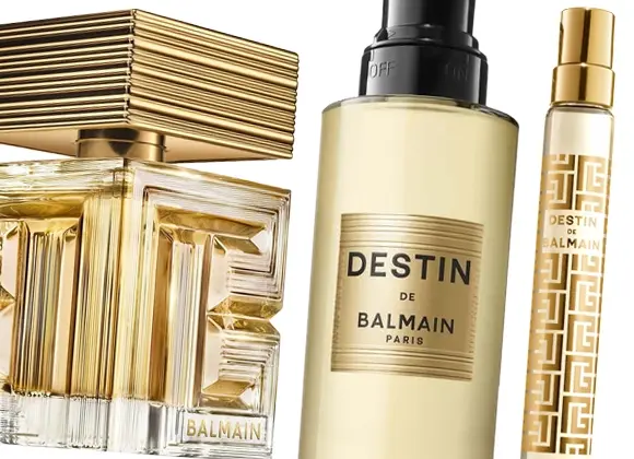 Tre parfymflaskor från Balmain, inklusive DESTIN DE BALMAIN PARIS, i guldfärgad design med dekorativa detaljer och transparent glas. Fokus på lyxig parfym, glasflaskor och guldfinish mot ljus bakgrund.