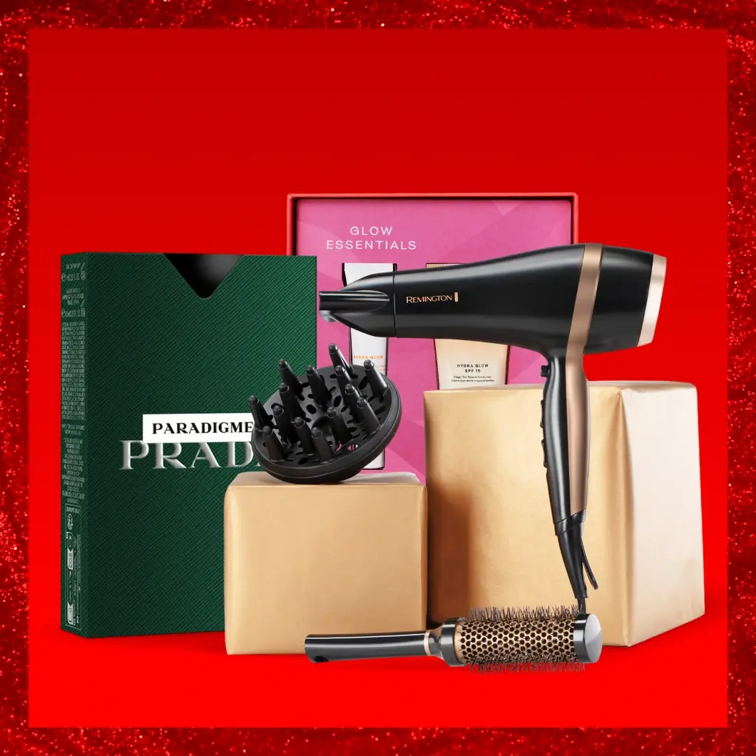 Skönhets- och personvårdsprodukter: Prada, Remington hårtork, Glow Essentials hudvård. Röd bakgrund.
