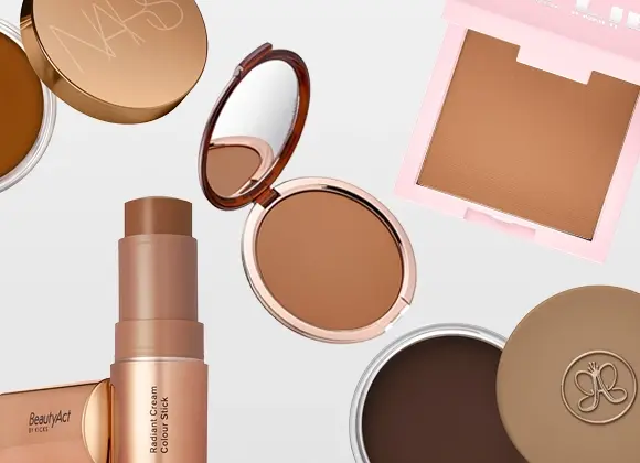 Tasokuva meikkituotteista vaalealla taustalla, mukana NARS-puuteri, BeautyAct By KICKS Radiant Cream Colour Stick sekä bronzer ja puuteri vaaleanpunaisissa ja kullanvärisissä pakkauksissa, yhdessä Anastasia Beverly Hills -logolla varustetun puuterirasian kanssa.
