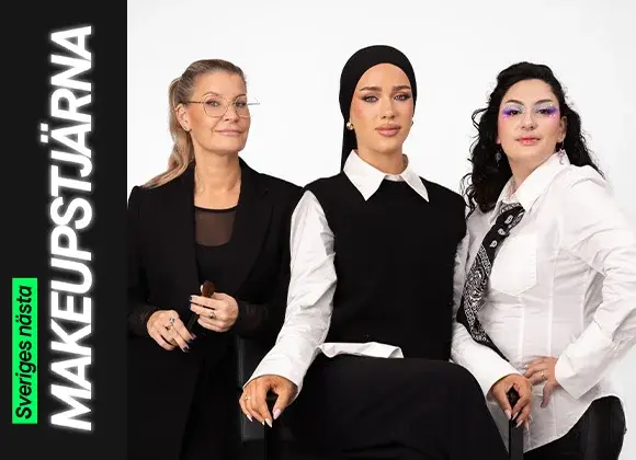 Tre personer sitter tillsammans, där en håller en makeupborste och de andra bär kreativa makeuplooker – en med markerad bas och eyeliner samt en med färgstark ögonmakeup med glitterdetaljer.