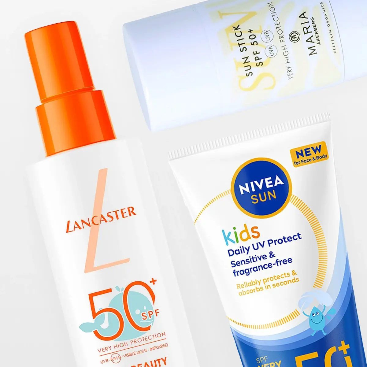 Kolme SPF 50+ aurinkosuojatuotetta vaaleanharmaata taustaa vasten: Lancaster Sun Beauty -aurinkosuihke oranssilla pumppupullolla, MÁDARA Sun Stick SPF50+ tekstillä “Very High Protection” sekä NIVEA Sun Kids Daily UV Protect Sensitive & fragrance-free for face & body. Pakkauksissa näkyy tekstit “UVA”, “UVB”, “NEW for Face & Body” ja “Reliably protects & absorbs in seconds”.