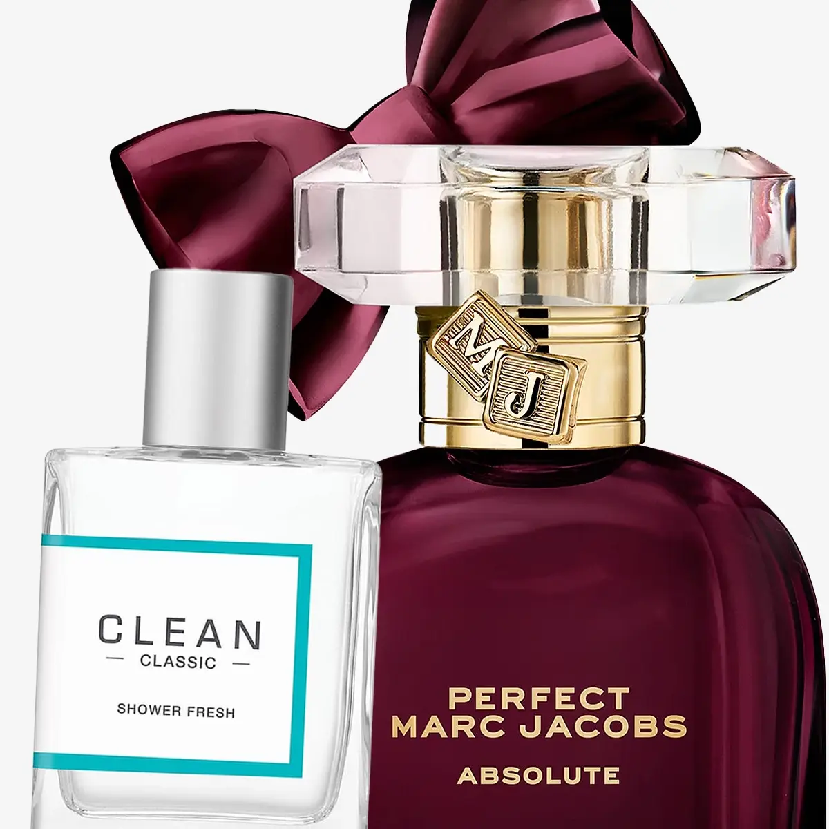 Kaksi hajuvesipulloa: Clean Classic Shower Fresh ja Perfect Marc Jacobs Absolute, burgundinpunaisella rusetilla.