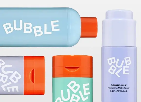 Useita Bubble-ihonhoitotuotteita pastellisävyissä vaaleaa taustaa vasten. Pakkauksia sinisenä, mintunvihreänä ja lilana oransseilla korkeilla sekä valkoisella logotekstillä, mukana pullo, jossa lukee “Cosmic Silk Hydrating Milky Toner 100 ml”.