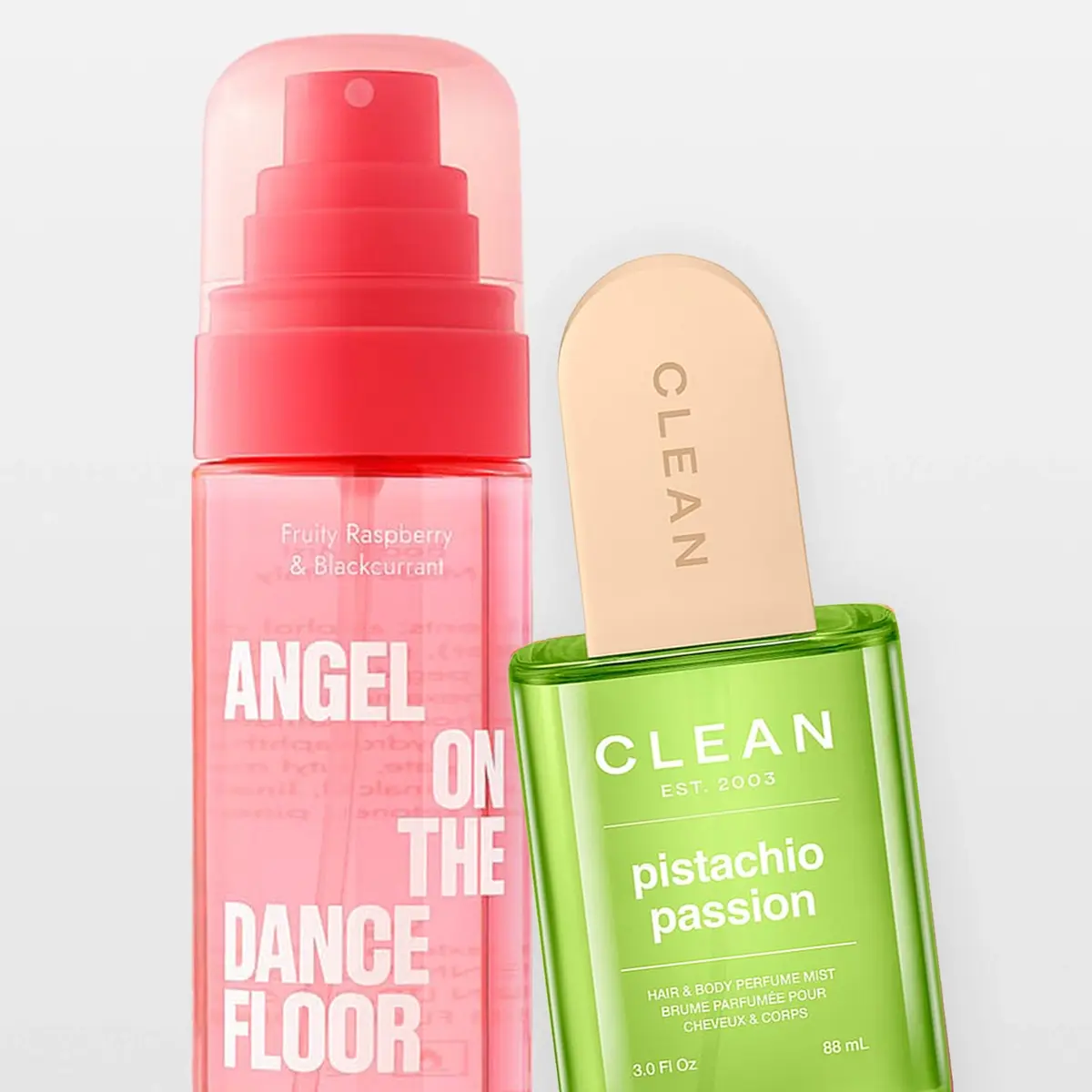 Två parfymmistprodukter mot ljusgrå bakgrund. Till vänster syns en rosa sprayflaska med texten “Fruity Raspberry & Blackcurrant” och “ANGEL ON THE DANCE FLOOR”, och till höger en grön CLEAN Pistachio Passion Hair & Body Perfume Mist med texten “CLEAN EST. 2003”, “pistachio passion” och “88 mL”.