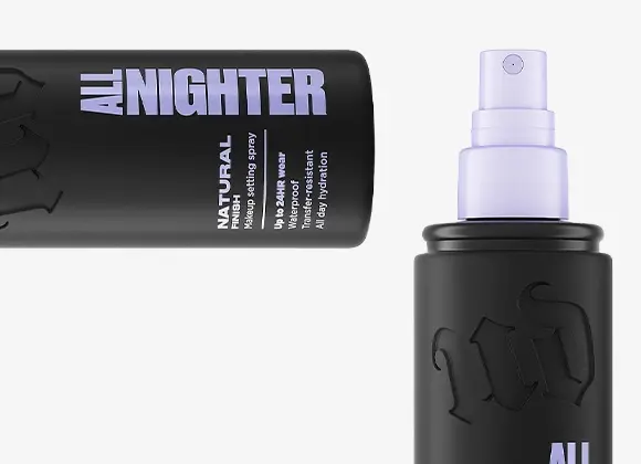 Urban Decay All Nighter makeup setting spray i svart flaska med lila spraymunstycke, en liggande och en stående. Synlig text: “ALL NIGHTER”, “NATURAL finish”, “Waterproof”, “Up to 16h wear”, “Makeup setting spray” och “All day hydration”.