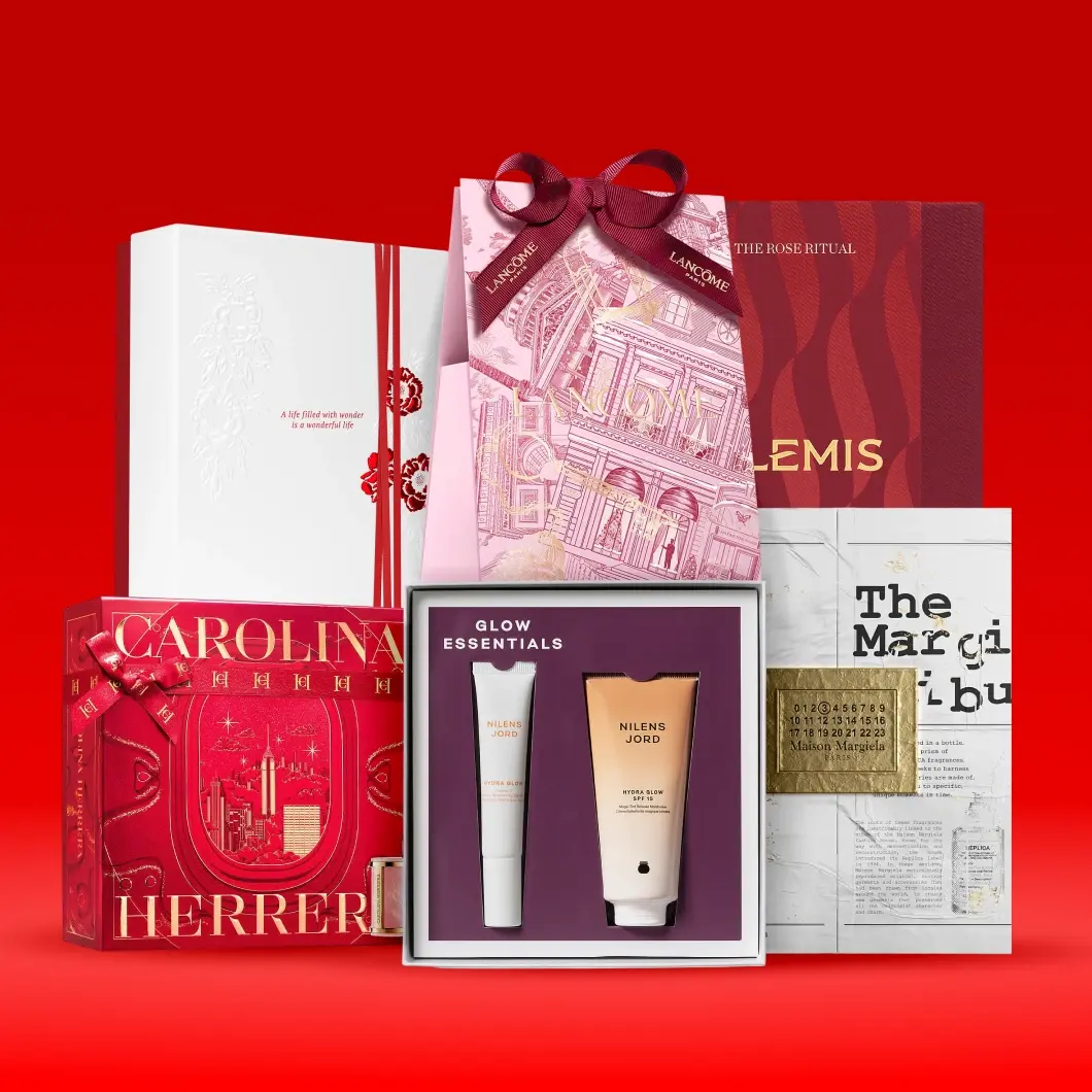 Sortiment av lyxiga skönhets- och hudvårdsgåvoset, inklusive Lancôme, Elemis och Nilens Jord, på röd bakgrund.