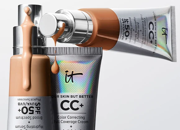 Tre CC-kremprodukter med SPF 50+ i en elegant metallisk innpakning, med CC-krem som drypper fra pumpene.