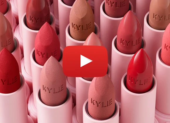 Rivit Kylie-huulipunaa punaisen ja vaaleanpunaisen eri sävyissä. Logo "Kylie" on kaiverrettu huulipunaan.