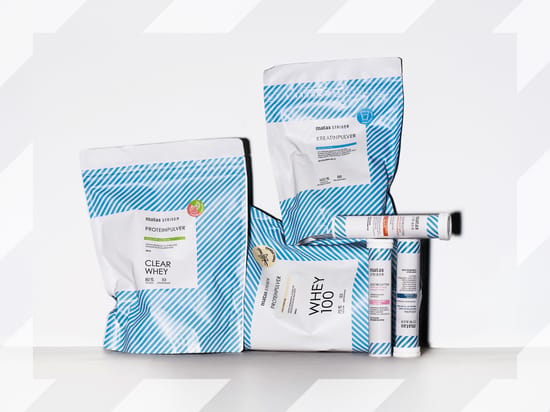 Sortiment af Matas Striber sportstilskud på hvid baggrund, bl.a. Clear Whey proteinpulver, Whey 100, kreatinpulver og elektrolytter.