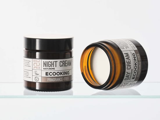 To brune glasbeholdere med parfumefri dag- og natcreme fra Ecooking, hvor den ene står åben, så den lyse creme er synlig.