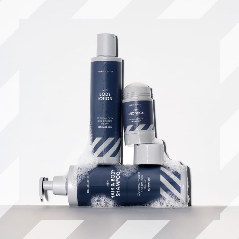 Her ses et billede med produkter fra Matas Men placeret mod en lys baggrund med Matas Stribers karakteristiske mønster. Produkterne omfatter “Men Body Lotion”, “Men Deo Stick” og “Men Hair & Body Shampoo”, som er arrangeret med sæbeskum omkring.