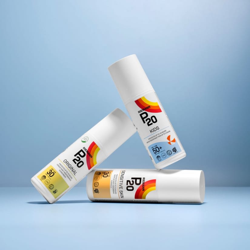 Her ses et billede med tre solplejeprodukter fra P20 placeret mod en lyseblå baggrund. Produkterne omfatter varianterne “Original SPF 30”, “Kids SPF 50+” og “Sensitive Skin SPF 30”, som er arrangeret balancerende oven på hinanden.