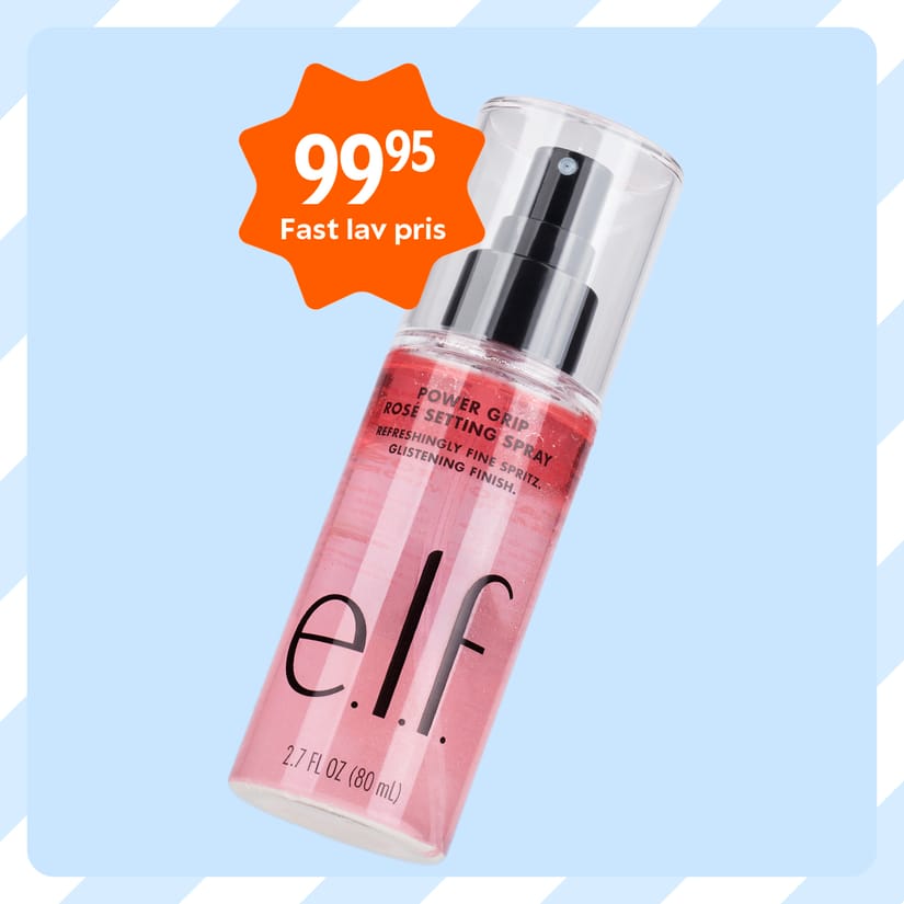Her ses e.l.f. Power Grip Dewy Setting Spray i en transparent flaske med rosa indhold og sort pumpe. På billedet står “99,95” og “Fast lav pris” i et orange prisfelt.